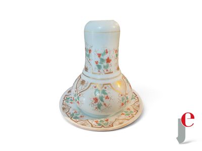 un petit vase blanc orné de fleurs, posé sur une soucoupe