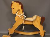 wooden rocking horse with a rope on the back of it