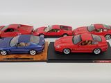 four red and blue model cars are on display on a wooden stand