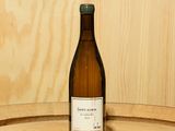 une bouteille de vin posée sur un tonneau en bois