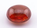 un gros plan d'une boule de verre rouge posée sur une surface blanche