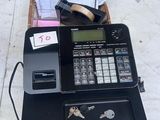 a cash register sitting on top of a table next to a bunch of keys