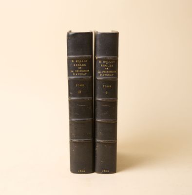 deux livres noirs posés l'un sur l'autre sur une surface blanche