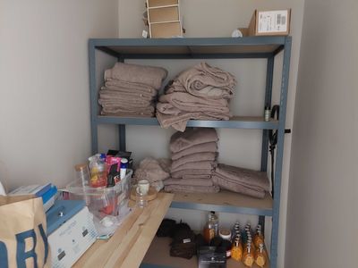 a shelf that has a lot of towels and bottles on it