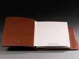 a close up of an open book on a table with a black background