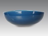 un bol bleu sur fond blanc, avec un fond gris
