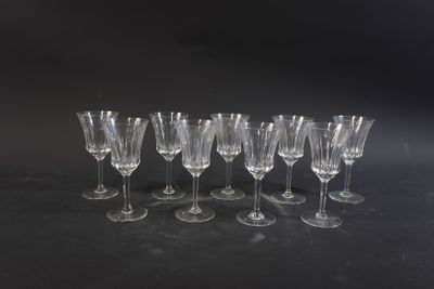 six empty wine glasses lined up in a row on a black surface