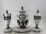 three vases and a clock sitting on a table