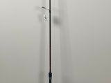 the fishing rod is next to the umbrella on the floor