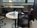 un bureau sur lequel se trouve un ordinateur portable, avec une chaise devant