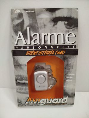 image d'un dispositif d'alarme dans un boîtier posé sur une surface blanche
