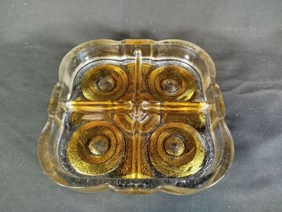 un plateau en verre orné de quatre anneaux dorés