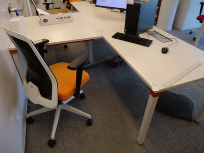 un bureau avec un ordinateur et une chaise dans un coin