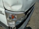 a close up of a white truck with a dent in it ' s head