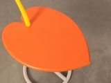 an orange table with a yellow handle on top of it