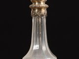 an image of a clear glass bottle with a gold top