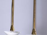 une paire de suspensions en laiton et en verre blanc suspendues au plafond