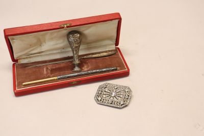 a small silver object in a red box next to a coin