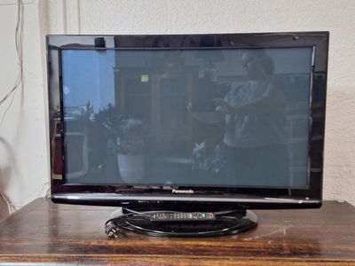 une télévision à écran plat posée sur une table en bois