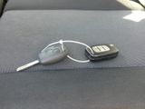 a remote control and a car key on the seat of a car