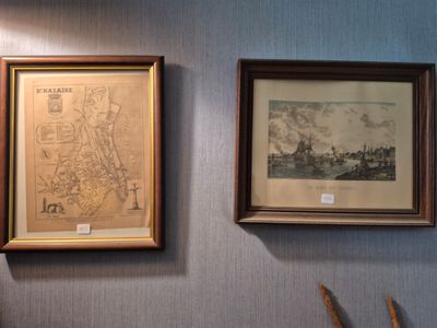 two framed maps hanging on the wall next to a pair of scissors
