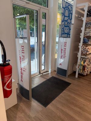 un magasin avec une grande porte vitrée et un paillasson noir au sol