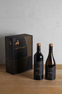 two bottles of wine sitting on a table next to a box