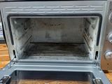 an open oven sitting on top of a wooden table
