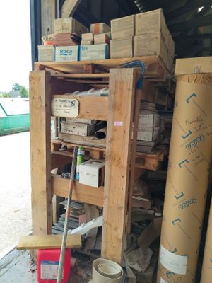 une pile de cartons et une serpillière devant un immeuble