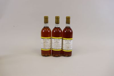 trois bouteilles de vin posées les unes à côté des autres sur une surface blanche