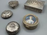 Plusieurs objets en argent sont posés les uns à côté des autres sur une table.