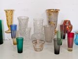 de nombreux vases et verres en verre de différentes couleurs sur la table
