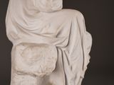a statue of a woman sitting on a stone block