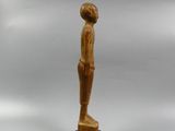 a wooden statue of a man standing on a wooden base