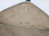 a tan bag with a black handle hanging from it ' s side