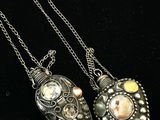 deux colliers en argent ornés de pierres de différentes couleurs, posés sur un fond noir