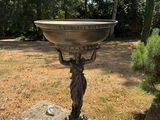 a statue of a woman holding a bowl on top of a pedestal