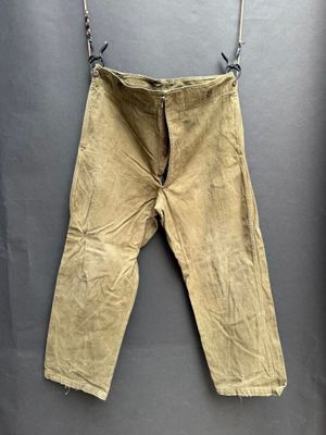 un vieux pantalon suspendu à une corde à linge fixée au mur