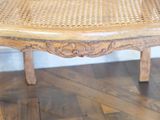 a wooden chair with a wicker seat on a hard wood floor