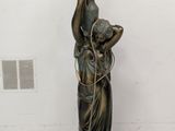 une statue représentant une femme tenant un panier sur la tête