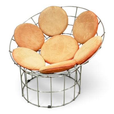 a metal chair that has a bunch of pillows on it