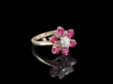 un gros plan d'une bague sertie d'un diamant rose et blanc sur une surface noire