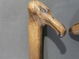 two wooden birds that are standing next to each other