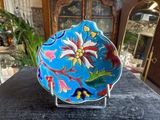 a blue plate with a flower on it on a table