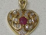 an image of a heart shaped pendant with a ruby stone in the center