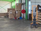 many boxes and pallets in a warehouse with a fork lifter