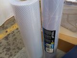 two rolls of plastic sitting on a table next to a book