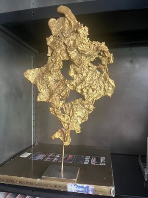 a gold leaf sculpture on display in a glass case