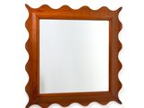 un miroir sur le mur au-dessus d'un lavabo dans une salle de bains