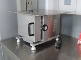 a small oven sitting on top of a stainless steel counter
